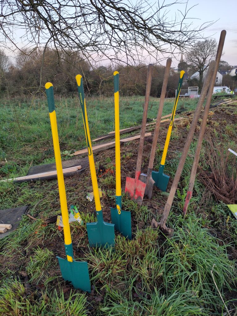 plantation pelle portrait plusieurs pelles et bêches plantées dans une butte de terre